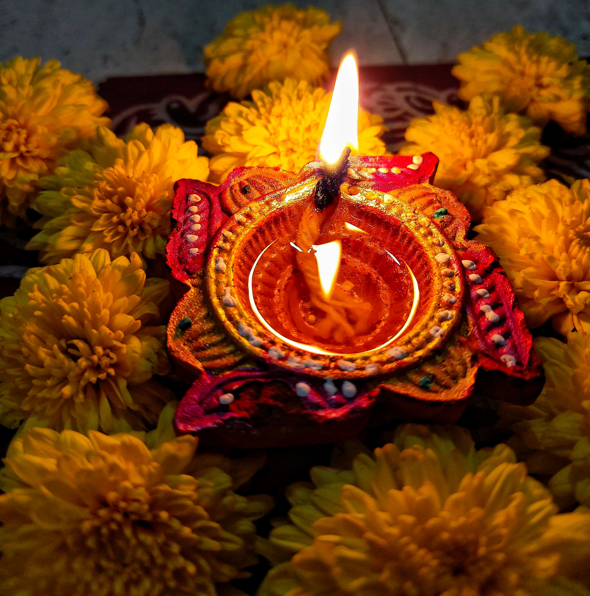 Diwali-Diya zwischen gelben Blüten
